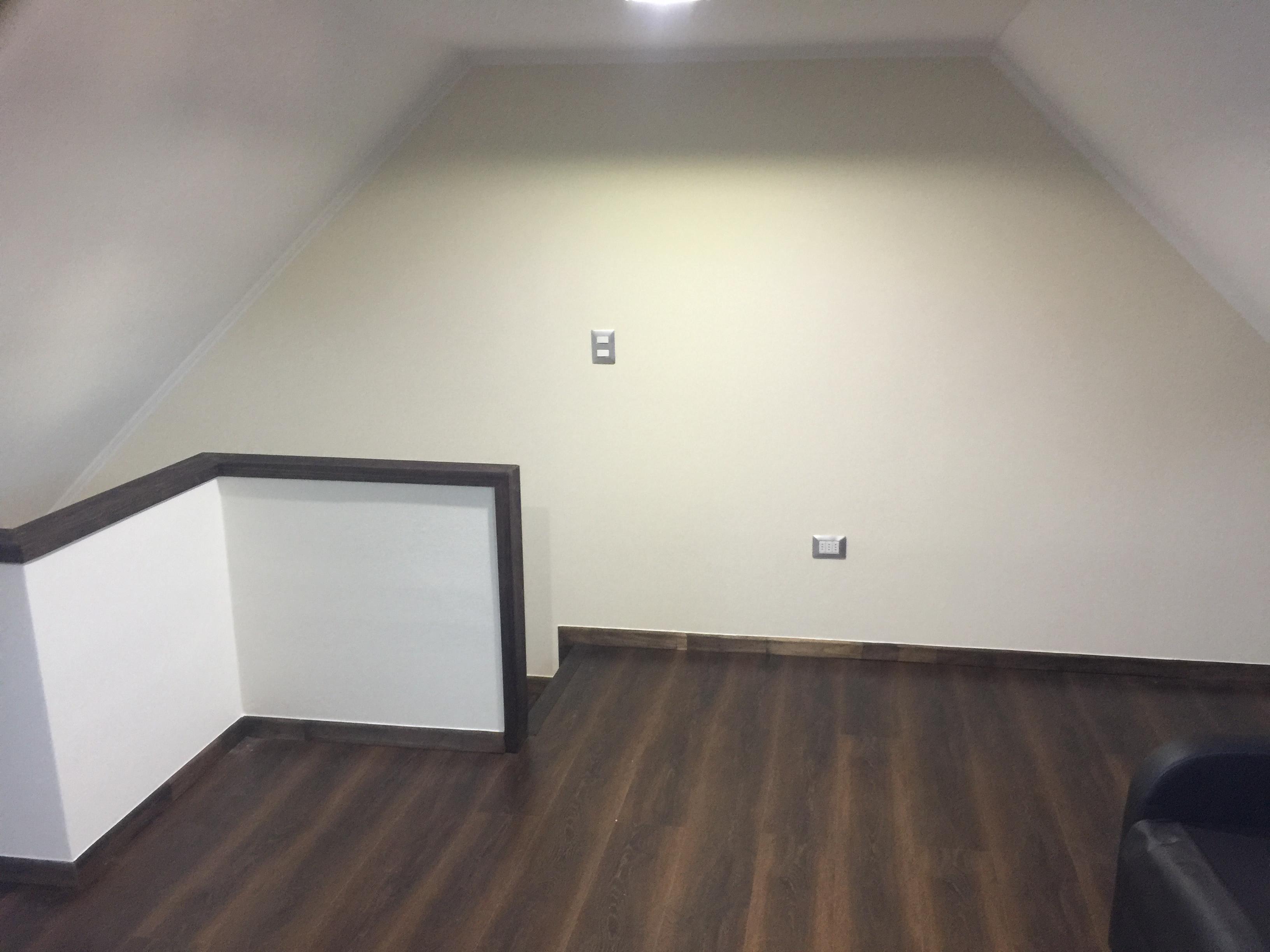 Escalera metálica negra con peldaños de madera y baranda de cristal en casa moderna