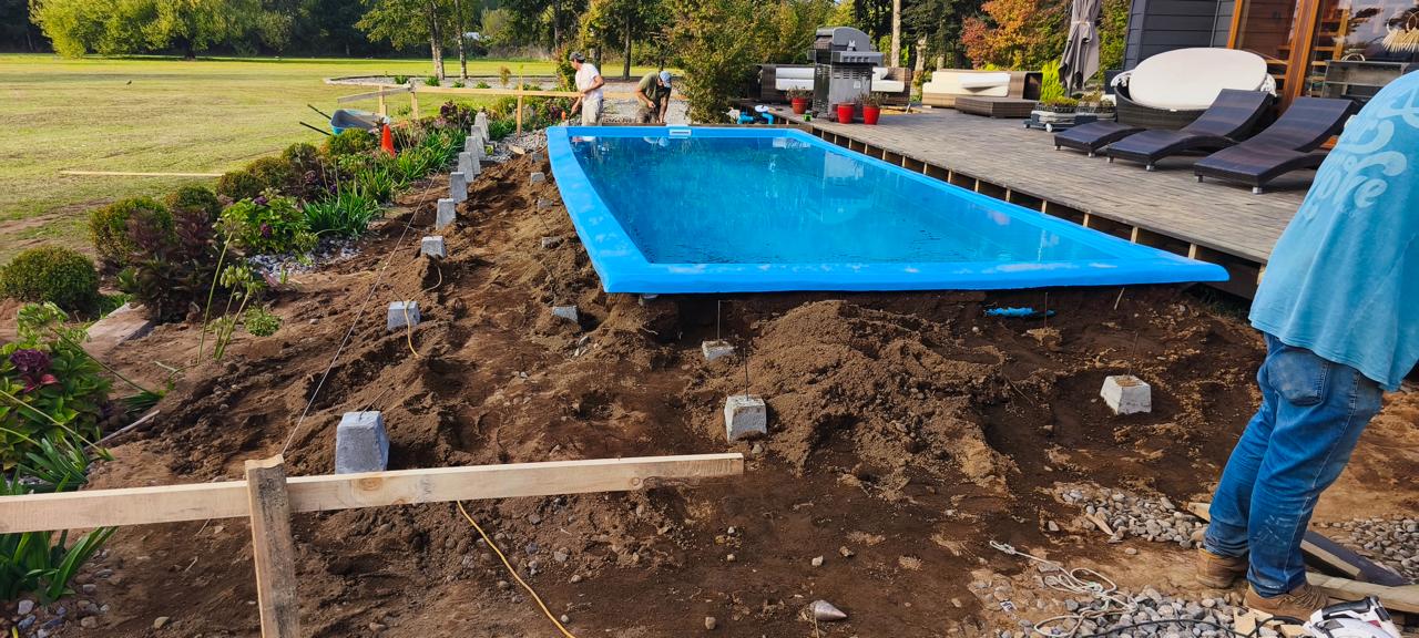 Piscina rectangular terminada e iluminada de noche, con terraza de madera